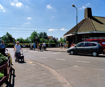 844494 Gezicht op de gesloten spoorwegovergang in de Stationsstraat te Vleuten (gemeente Utrecht), met rechts het ...